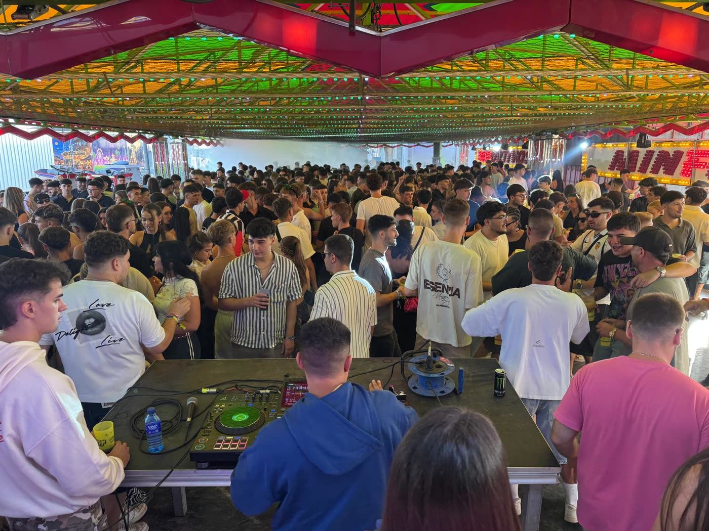 Pista de coches de choque llena de gente con sesión de DJ